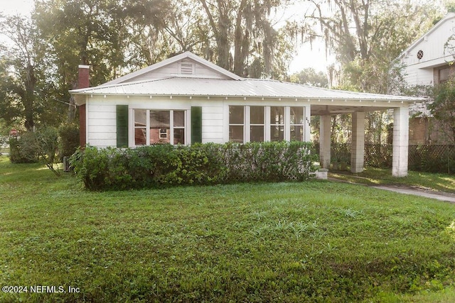 762 N Walnut St, Starke, FL 32091 - view of front of house featuring a front lawn, a chimney, and metal roof