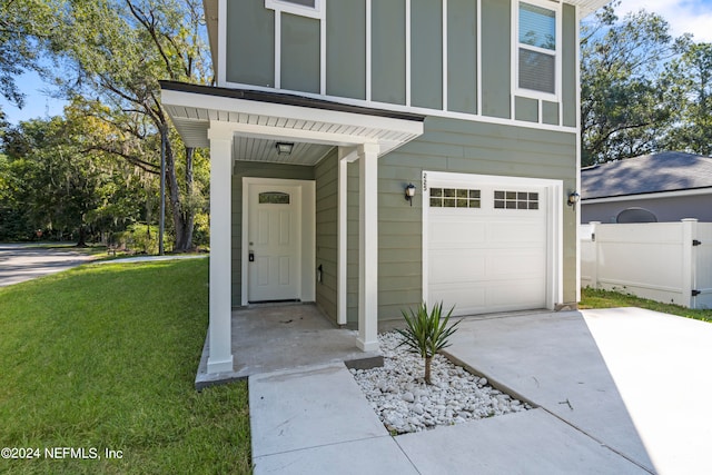 property entrance featuring a yard and a garage