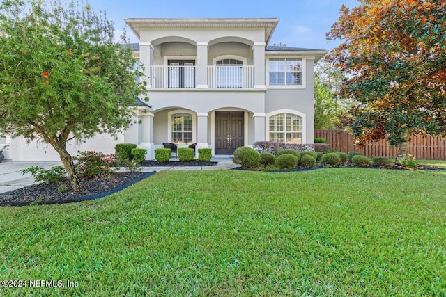 view of front of home featuring a front yard and a balcony