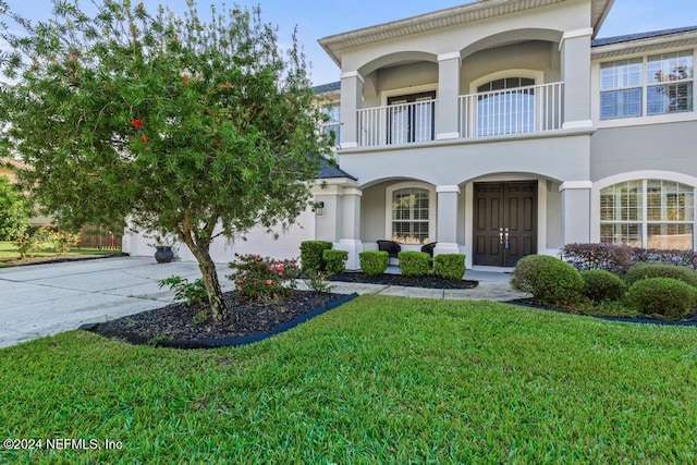 view of front of house with a balcony and a front yard