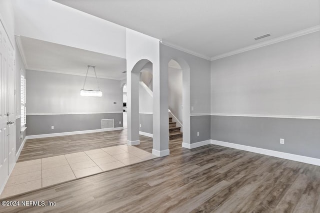 unfurnished room with wood-type flooring and ornamental molding