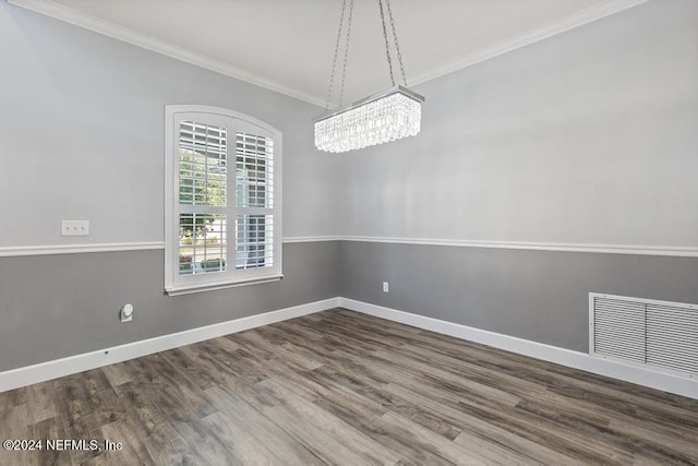 spare room featuring hardwood / wood-style flooring and ornamental molding