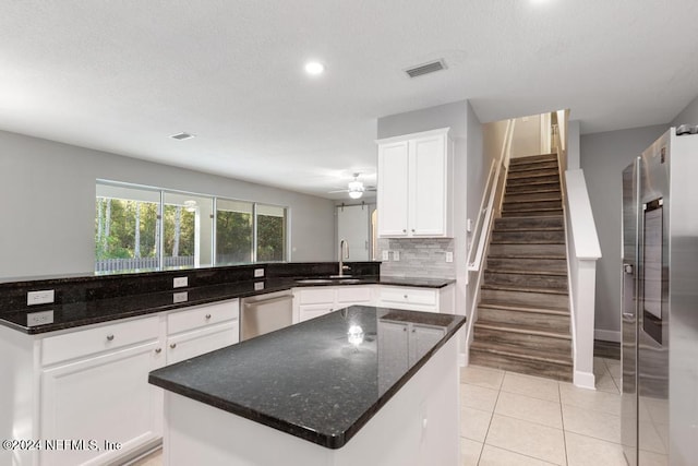 kitchen with dark stone countertops, white cabinetry, ceiling fan, and appliances with stainless steel finishes