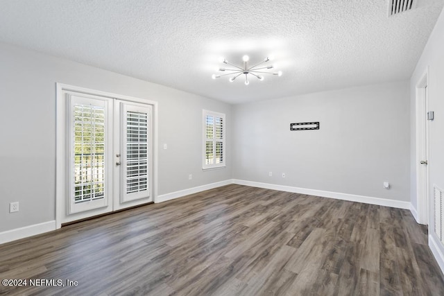 spare room with a healthy amount of sunlight, dark hardwood / wood-style flooring, and a textured ceiling