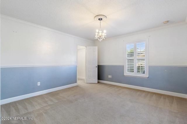 carpeted spare room with a textured ceiling, an inviting chandelier, and crown molding