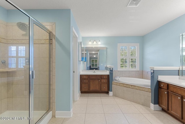 bathroom featuring tile patterned floors, vanity, plus walk in shower, and a textured ceiling