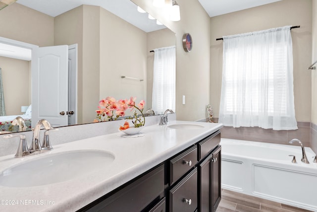 bathroom featuring vanity, a tub to relax in, and wood-type flooring