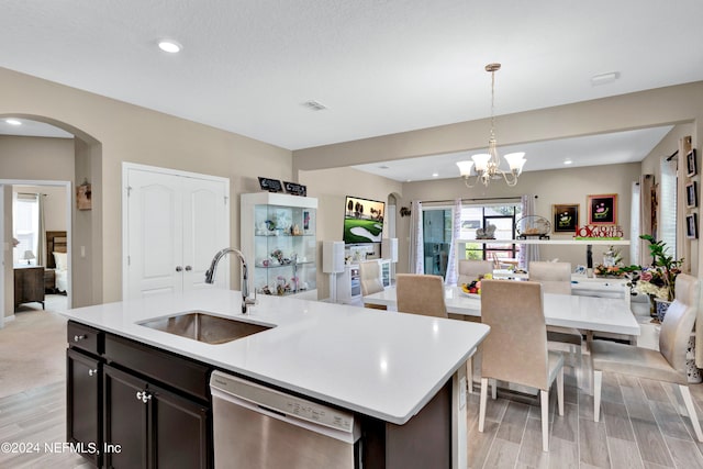 kitchen featuring light hardwood / wood-style floors, dishwasher, sink, and decorative light fixtures