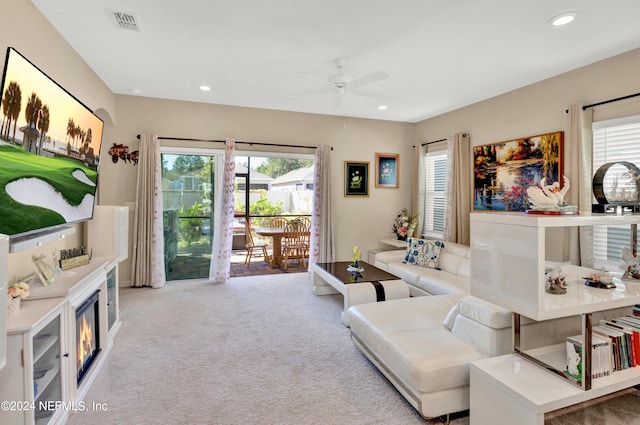 living room with light colored carpet, a healthy amount of sunlight, and ceiling fan