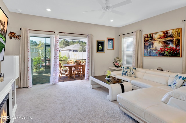 carpeted living room featuring ceiling fan