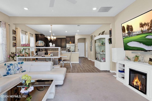 living room with carpet flooring and ceiling fan with notable chandelier