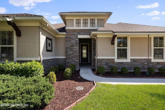 entrance to property featuring a lawn