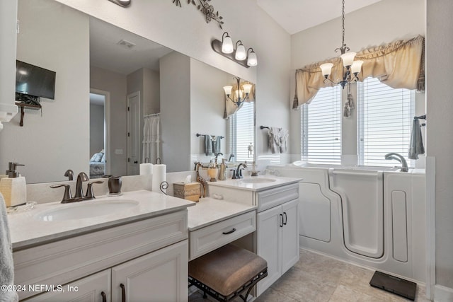 bathroom with vanity, an inviting chandelier, and tile patterned floors