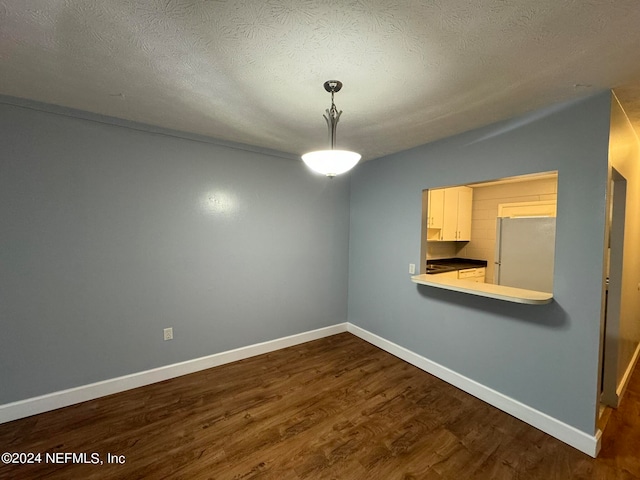 unfurnished dining area featuring hardwood / wood-style floors and a textured ceiling