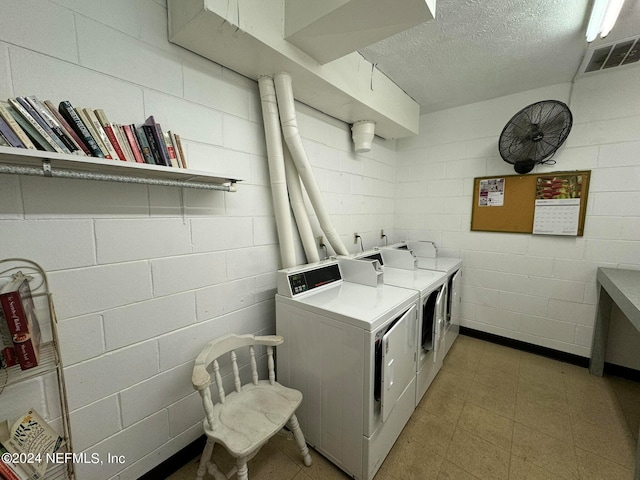 washroom featuring independent washer and dryer and a textured ceiling