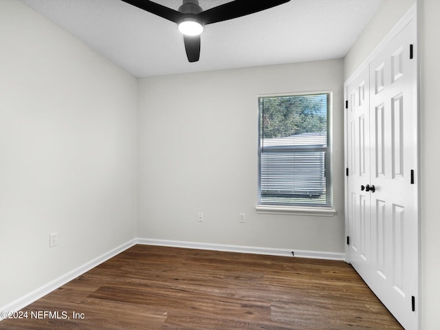 unfurnished room with ceiling fan and dark hardwood / wood-style flooring