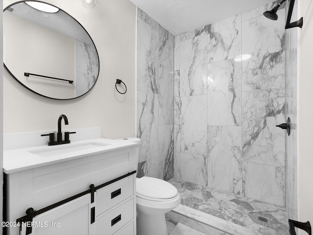 bathroom with vanity, toilet, and tiled shower