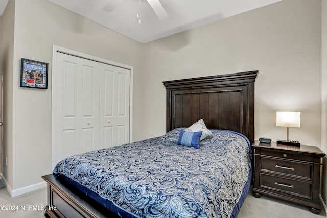 bedroom with ceiling fan, light carpet, and a closet