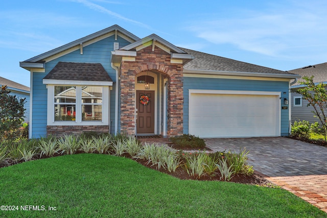 view of front of property featuring a garage and a front lawn