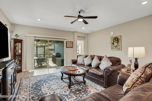 living room with ceiling fan and light hardwood / wood-style flooring