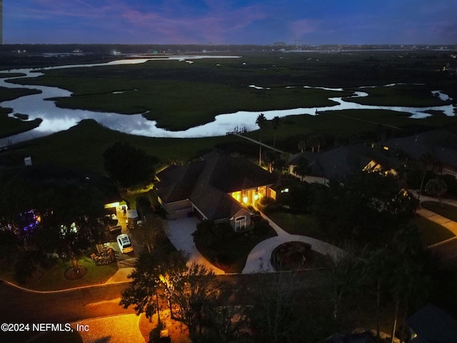 aerial view at dusk featuring a water view