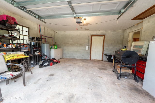 garage featuring washing machine and dryer, a garage door opener, and water heater