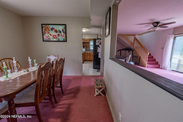 carpeted dining area featuring a textured ceiling and ceiling fan