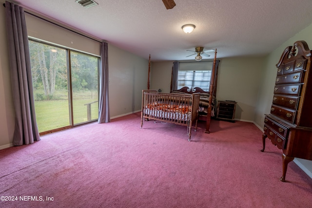 bedroom featuring multiple windows, carpet, a textured ceiling, and ceiling fan