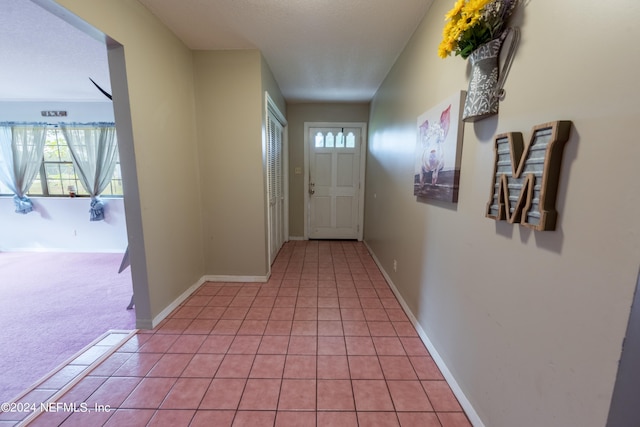 hall featuring light tile patterned floors