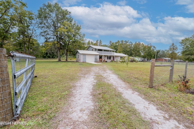 view of front of home featuring an outbuilding, a rural view, a garage, and a front yard