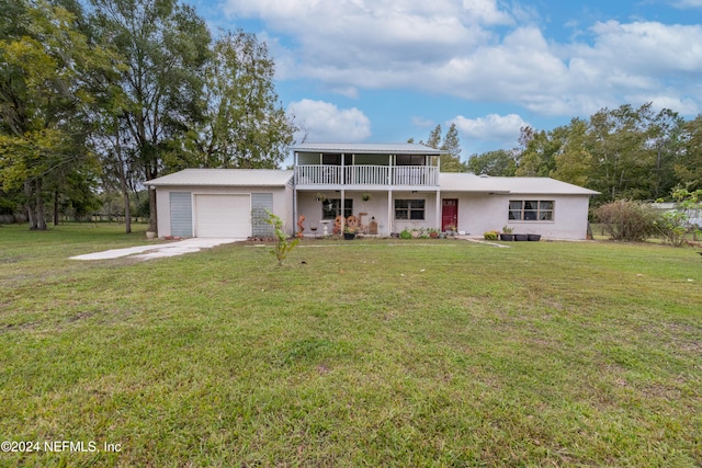 front facade featuring covered porch, a garage, and a front yard