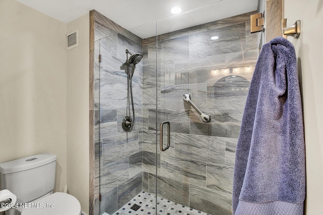 bathroom featuring a shower stall, toilet, and visible vents