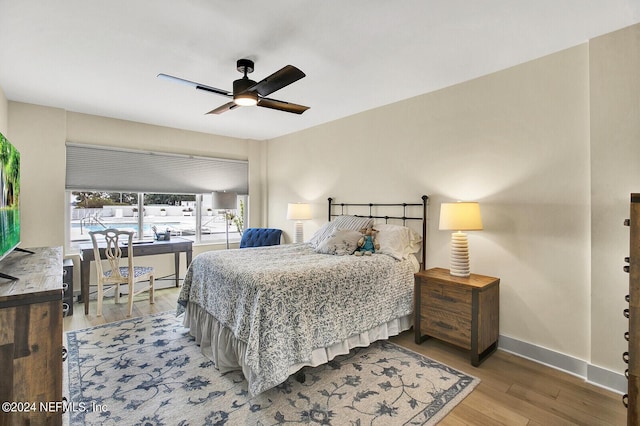 bedroom featuring baseboards, a ceiling fan, and light wood-style flooring