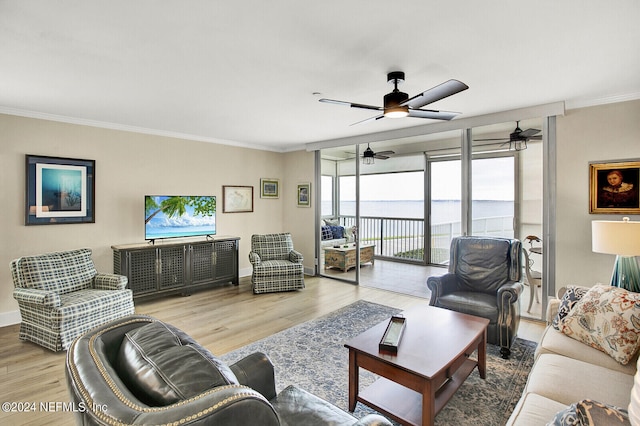 living area with ceiling fan, light wood finished floors, baseboards, and ornamental molding