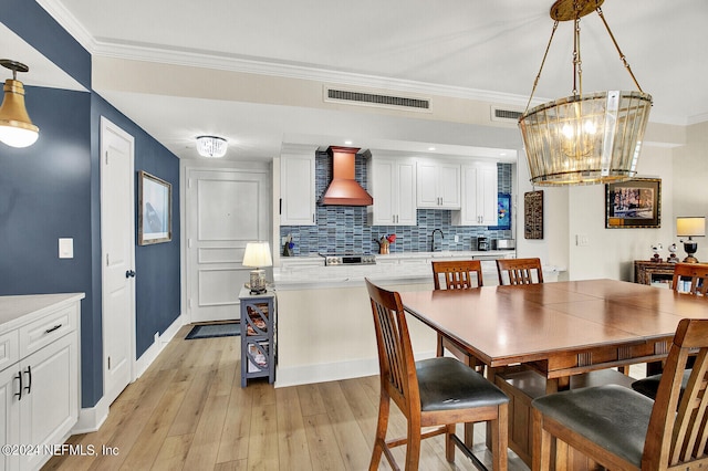 dining space with baseboards, light wood finished floors, a chandelier, and visible vents