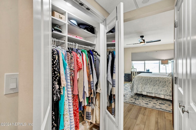 walk in closet featuring hardwood / wood-style flooring and ceiling fan