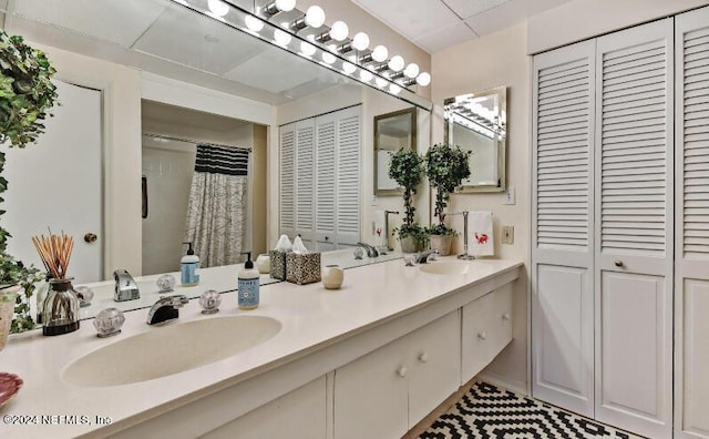 full bathroom with double vanity, a closet, and a sink