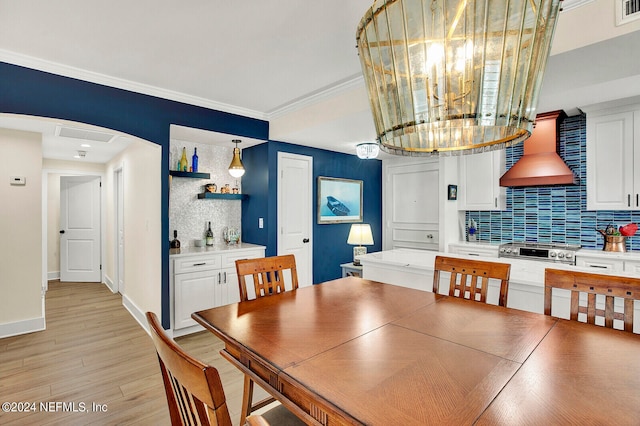 dining area with crown molding and light hardwood / wood-style floors