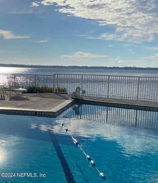 view of swimming pool featuring a water view