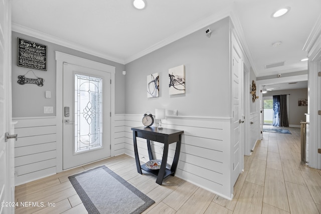 foyer featuring crown molding and light hardwood / wood-style flooring