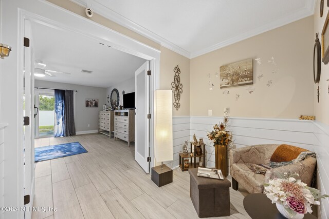 interior space featuring light hardwood / wood-style floors, ornamental molding, and ceiling fan