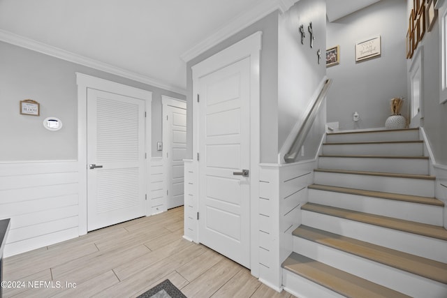 stairway featuring crown molding and wood-type flooring