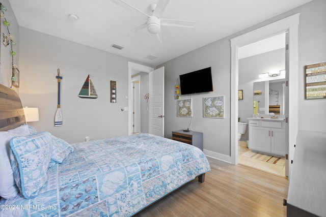 bedroom featuring light hardwood / wood-style flooring, ensuite bathroom, and ceiling fan