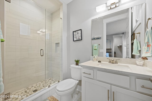 bathroom featuring vanity, tile patterned floors, toilet, and walk in shower