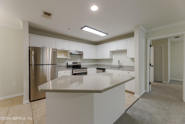 kitchen featuring appliances with stainless steel finishes, sink, a center island, white cabinetry, and light carpet