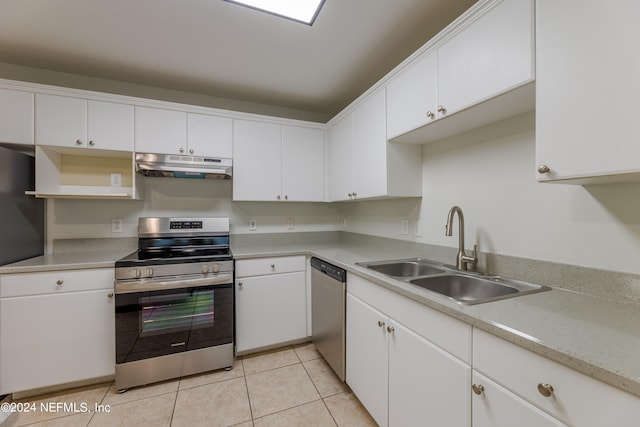 kitchen with stainless steel appliances, sink, light tile patterned flooring, and white cabinets