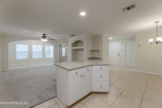 kitchen featuring ceiling fan with notable chandelier, white cabinetry, light carpet, decorative light fixtures, and crown molding