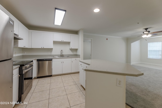 kitchen featuring appliances with stainless steel finishes, sink, a kitchen island, white cabinets, and light colored carpet