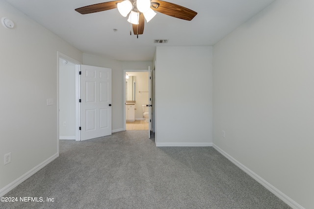 carpeted spare room with ceiling fan