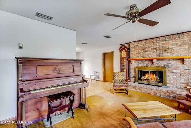 misc room featuring ceiling fan, light carpet, a textured ceiling, and a fireplace